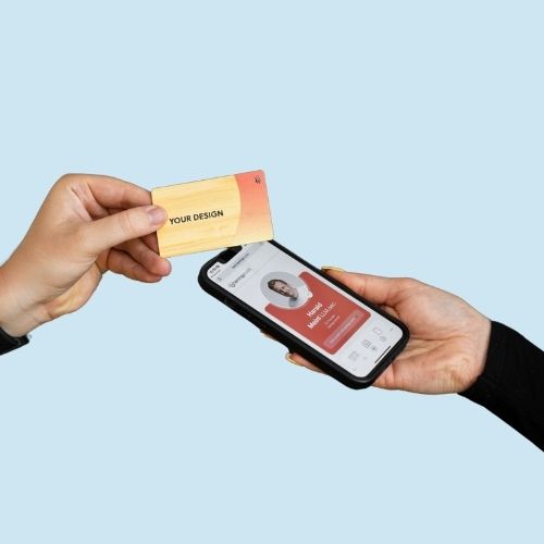 NFC Visitenkarte Bamboo Premium wird von einem Smartphone getappt, das eine geöffnete digitale Visitenkarte anzeigt