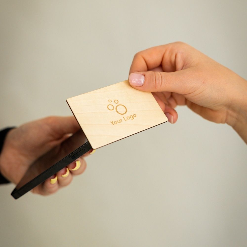 NFC Visitenkarte Birkenholz wird von einem Smartphone getappt