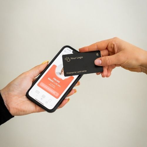 NFC Business Card Metal being tapped by a mobile phone displaying an open digital business card
