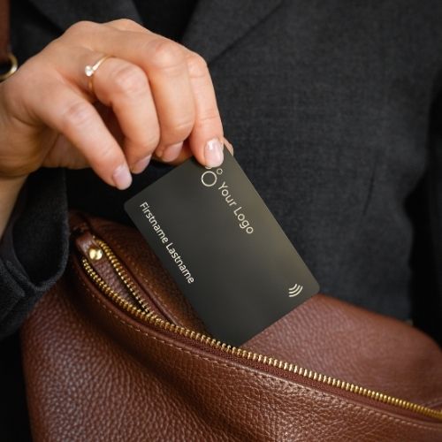 NFC Business Card Metal black being pulled out of a brown handbag