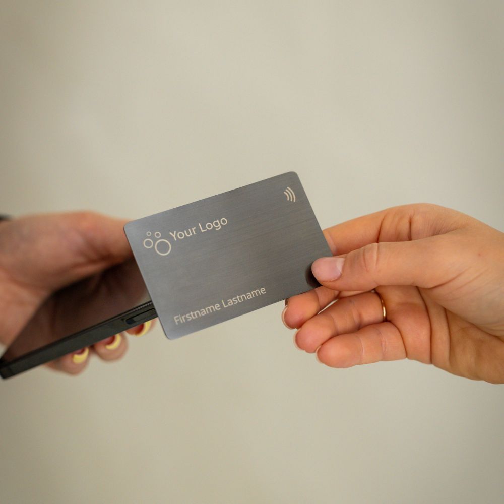 Brushed Metal Grey NFC Business Card being tapped by a mobile phone