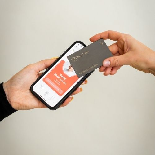 Brushed Metal Grey NFC Business Card being tapped by a mobile phone displaying an open digital business card