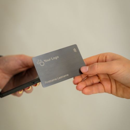 Brushed Metal Grey NFC Business Card being tapped by a mobile phone