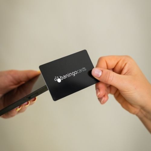 R-PVC NFC Visitenkarte Essential schwarz wird von einem Smartphone getappt