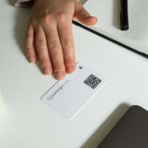R-PVC NFC Visitenkarte Essential weiß auf einem Schreibtisch