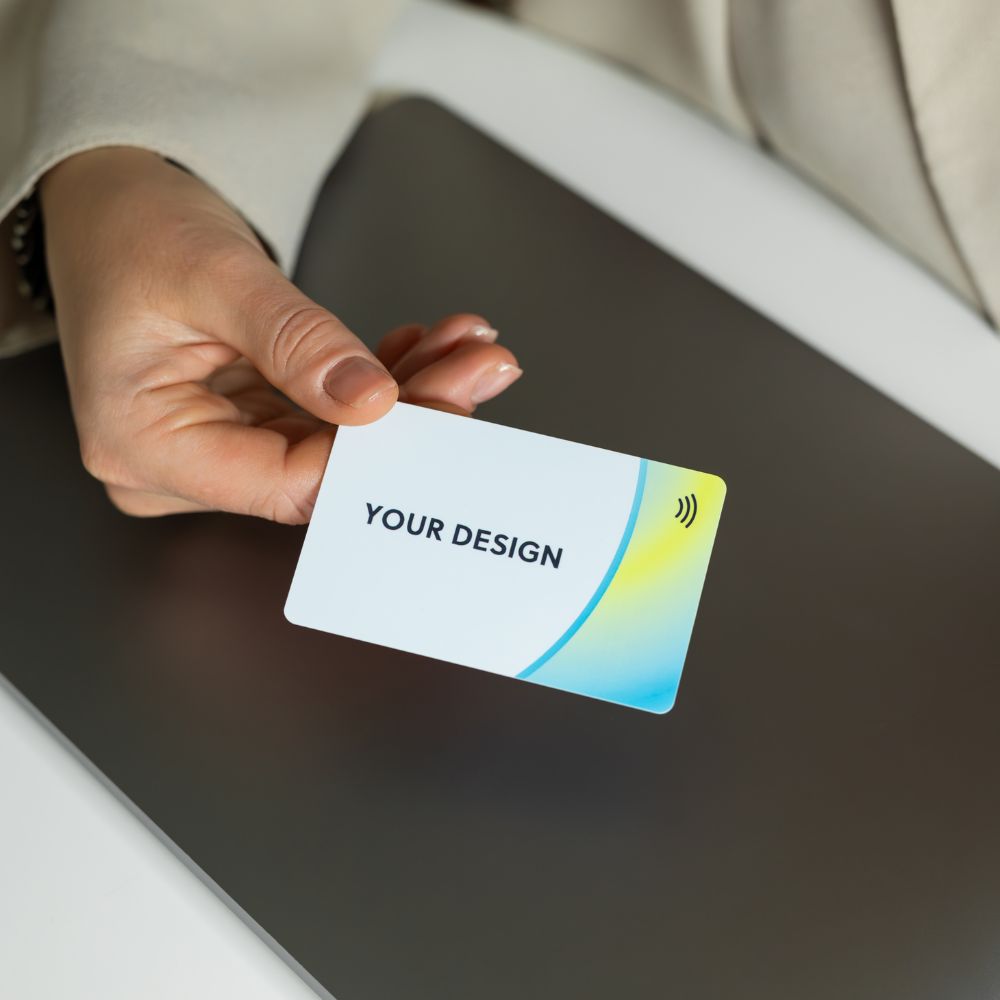 R-PVC Premium Edition NFC business card held by woman on a desk
