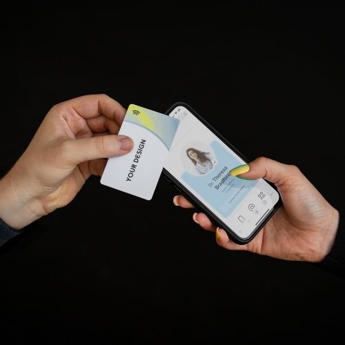 R-PVC Premium Edition NFC business card tapping a mobile phone, displaying open digital business card on black background