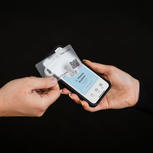 Transparente NFC Visitenkarte tippt auf ein Smartphone, digitale Visitenkarte auf schwarzem Hintergrund geöffnet